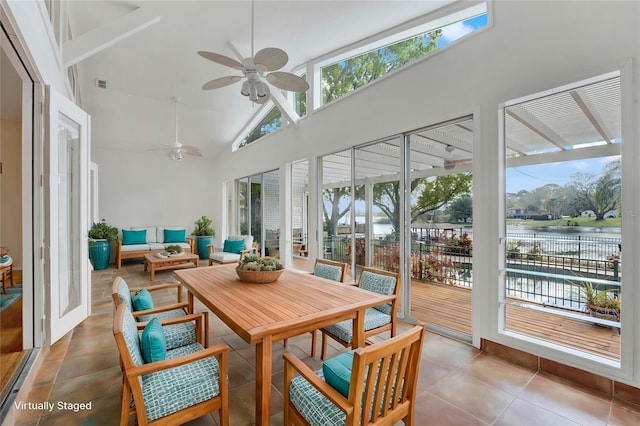 sunroom featuring lofted ceiling, ceiling fan, a water view, and visible vents