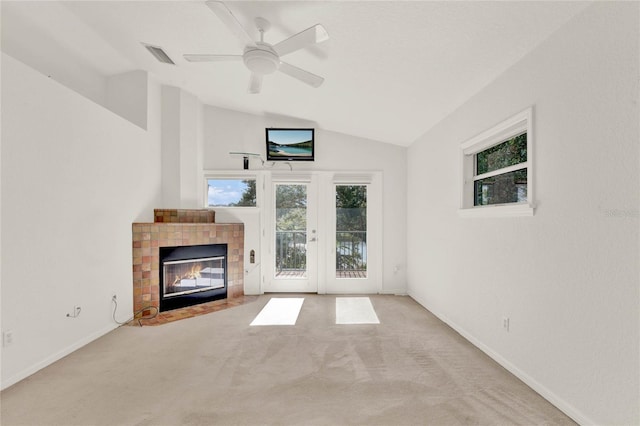 unfurnished living room with light carpet, visible vents, vaulted ceiling, and a tile fireplace