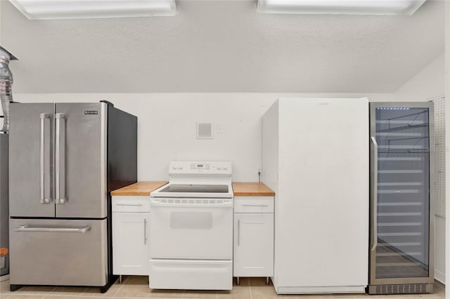 kitchen with white electric stove, white cabinets, wood counters, a textured ceiling, and high end fridge