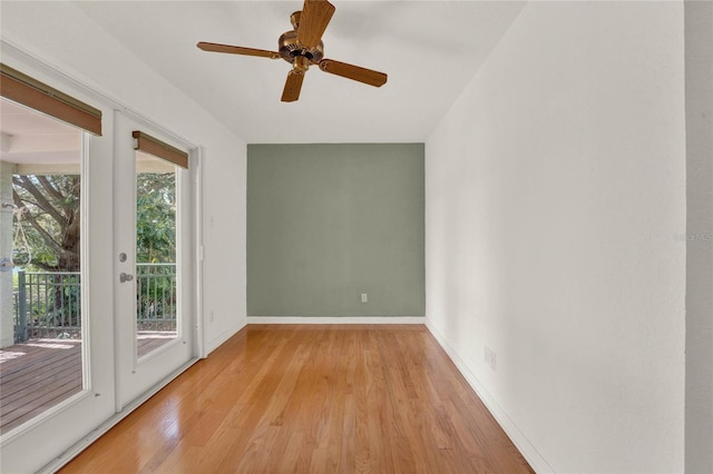 spare room with baseboards, ceiling fan, and light wood finished floors