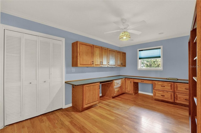 kitchen featuring a ceiling fan, light wood-type flooring, brown cabinetry, and built in study area