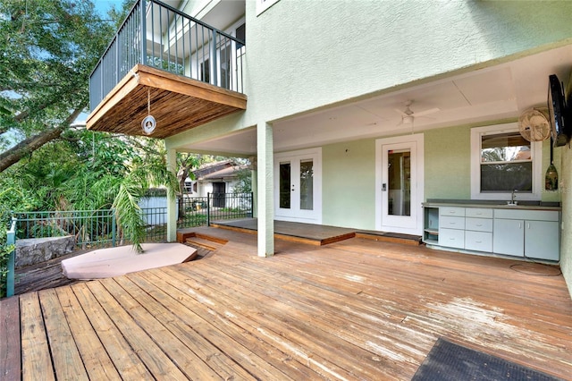 wooden deck with a sink, a ceiling fan, and fence