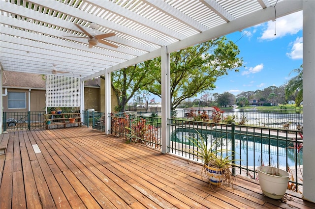 deck featuring a water view, ceiling fan, a fenced in pool, and a pergola