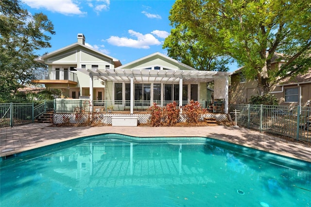 back of house with fence, a fenced in pool, and a pergola