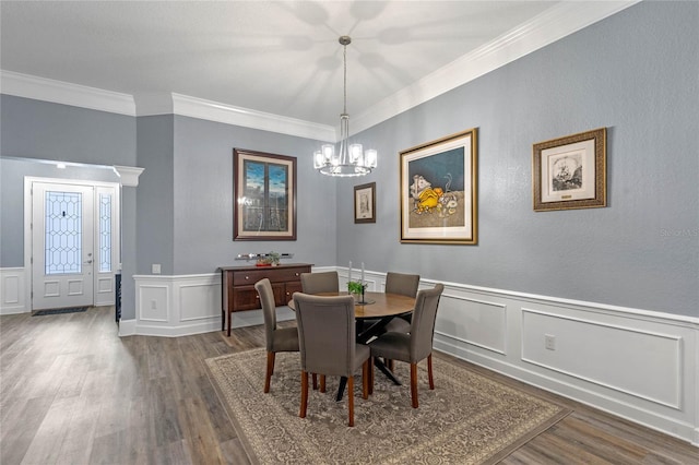 dining space with a chandelier, crown molding, and wood finished floors