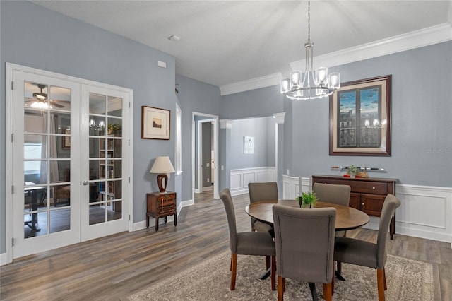 dining space featuring wainscoting, a decorative wall, wood finished floors, and french doors