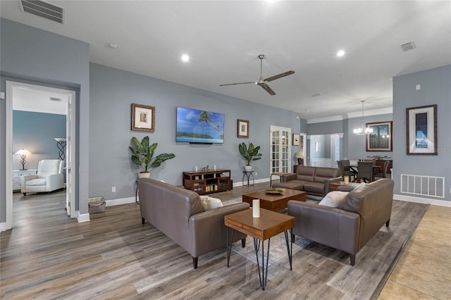 living area featuring baseboards, visible vents, and wood finished floors