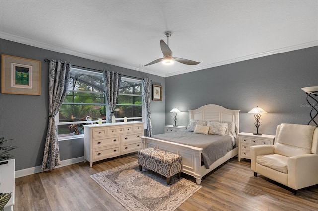 bedroom with a ceiling fan, baseboards, dark wood-style flooring, and crown molding