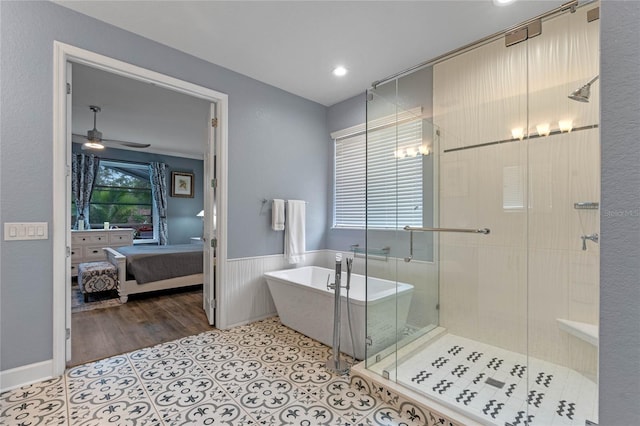 ensuite bathroom with a stall shower, a ceiling fan, connected bathroom, wainscoting, and a soaking tub