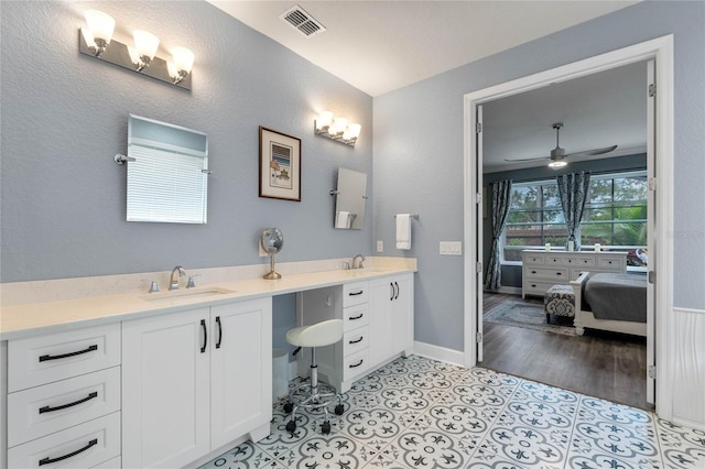 ensuite bathroom with tile patterned flooring, visible vents, a sink, and double vanity