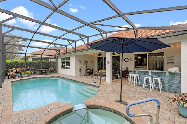 view of swimming pool featuring a lanai, a patio area, a pool with connected hot tub, and outdoor dry bar