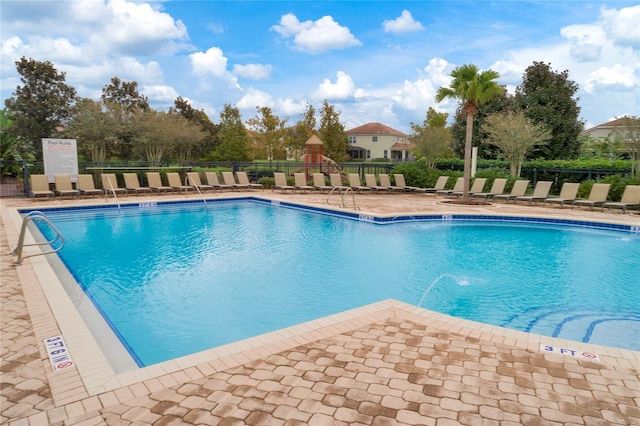 pool with a patio area and fence