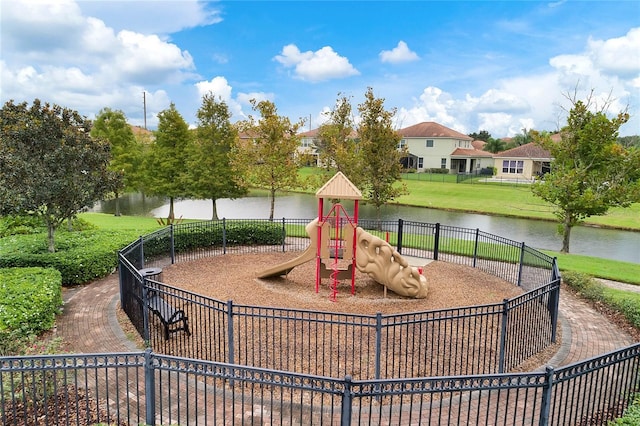 community jungle gym featuring a water view, fence, and a yard