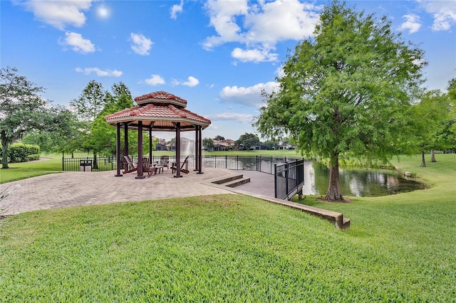 view of property's community featuring a yard, a water view, a gazebo, a patio area, and fence