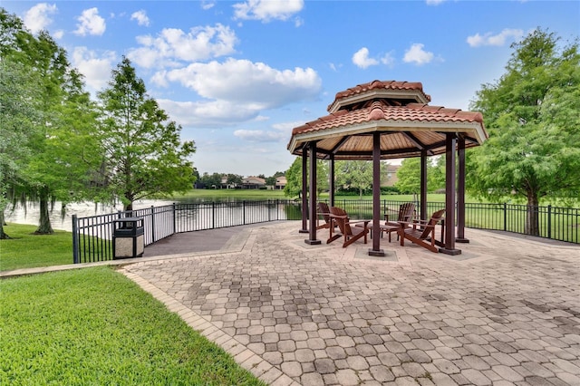 surrounding community with a water view, a yard, fence, and a gazebo