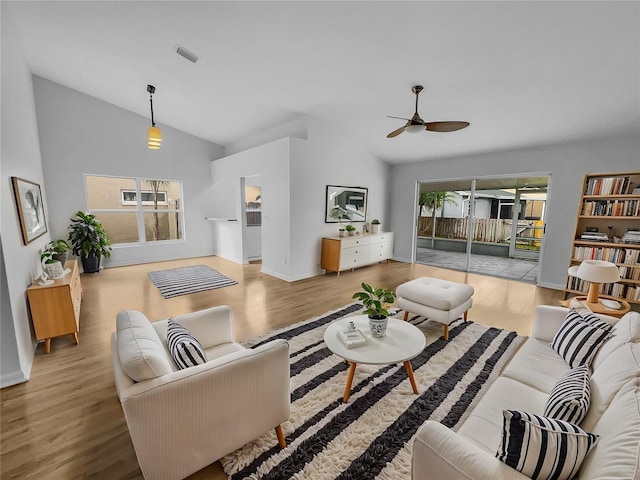 living room with ceiling fan, lofted ceiling, and light hardwood / wood-style floors