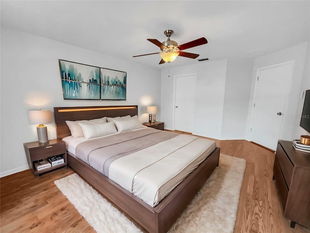 bedroom featuring ceiling fan, light hardwood / wood-style floors, and a closet