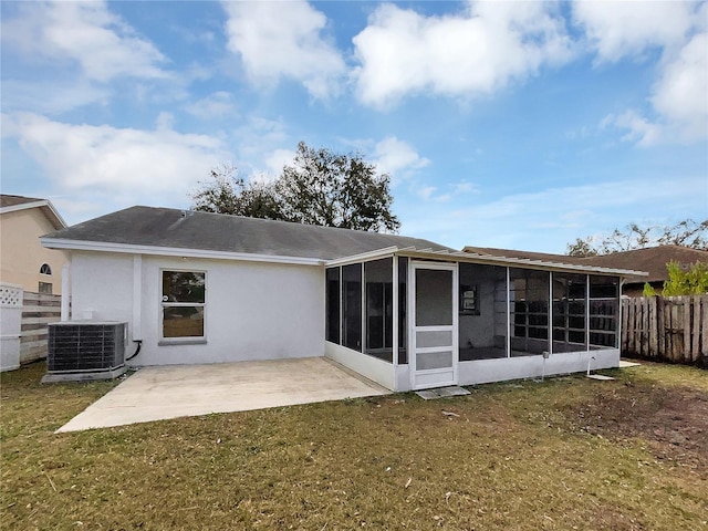 rear view of house with a sunroom, a yard, a patio area, and central air condition unit