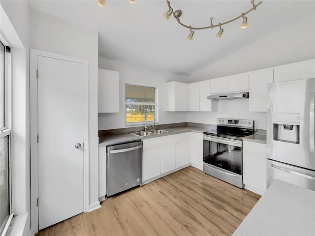 kitchen with sink, appliances with stainless steel finishes, light hardwood / wood-style floors, white cabinets, and vaulted ceiling