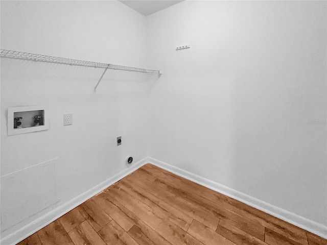 clothes washing area featuring electric dryer hookup, hookup for a washing machine, and hardwood / wood-style flooring