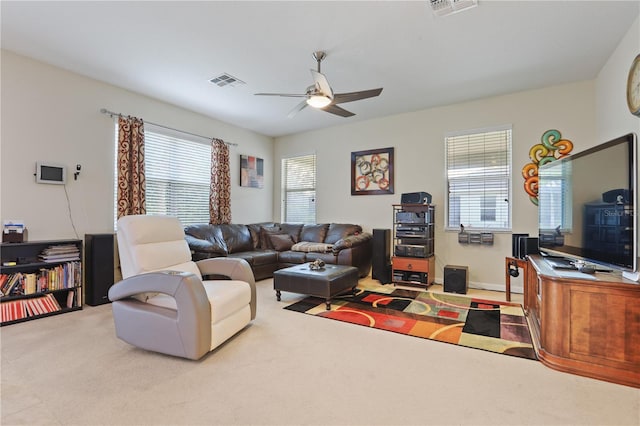 living room featuring light carpet, ceiling fan, visible vents, and baseboards