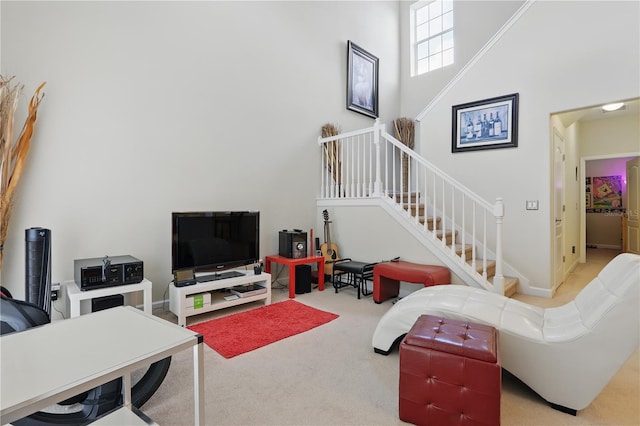 carpeted living area featuring a towering ceiling and stairs