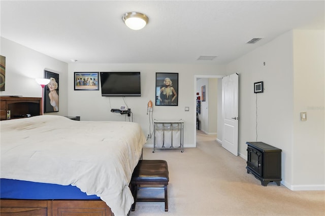 bedroom with baseboards, visible vents, and light colored carpet