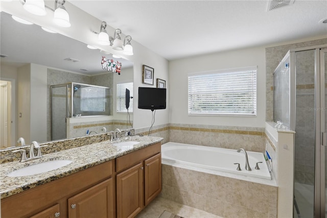 bathroom featuring a healthy amount of sunlight, a shower stall, visible vents, and a sink