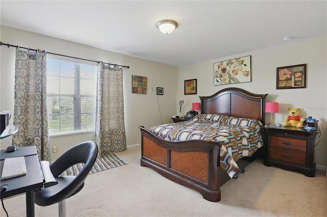 bedroom with baseboards and light colored carpet