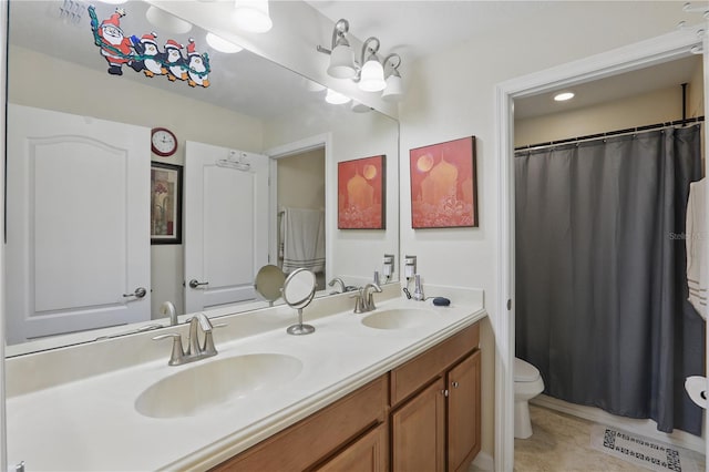 full bath with double vanity, a sink, toilet, and tile patterned floors