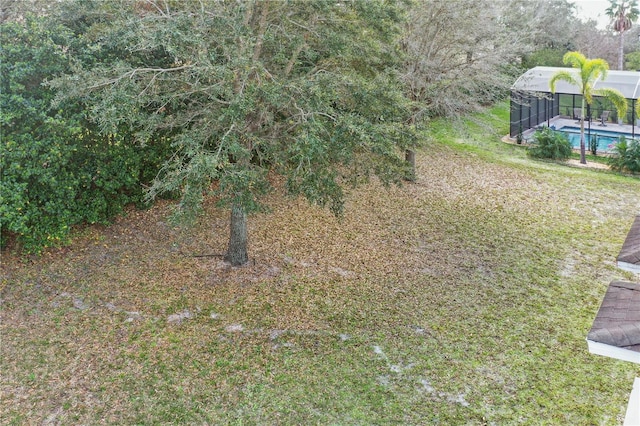 view of yard with glass enclosure and an outdoor pool