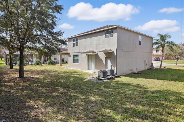 back of property with a yard, cooling unit, and stucco siding