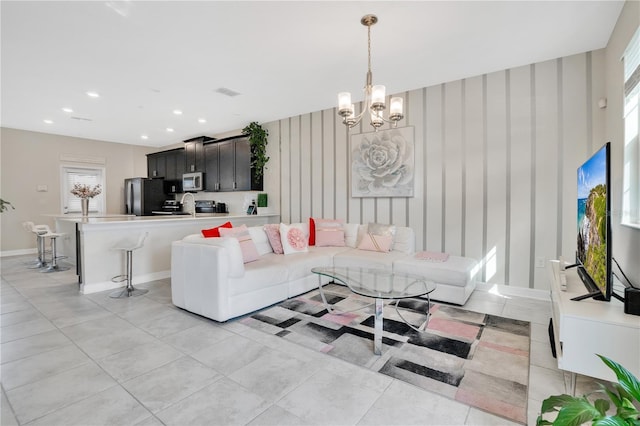 tiled living room featuring sink and a notable chandelier