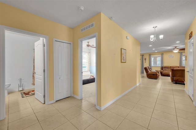 15506 Gemini Dr, Mascotte, FL 34753 - hallway featuring an inviting chandelier and light tile patterned floors