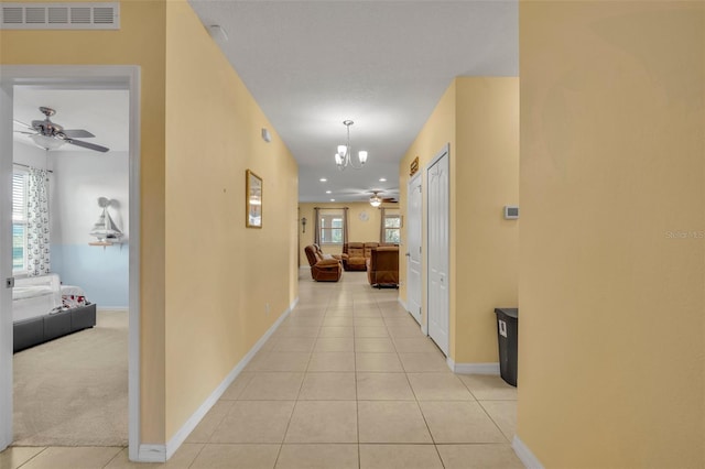 15506 Gemini Dr, Mascotte, FL 34753 - corridor featuring a notable chandelier, a wealth of natural light, and light tile patterned floors