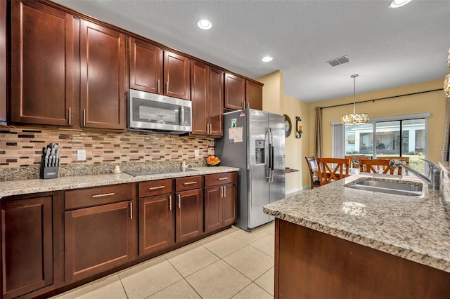 15506 Gemini Dr, Mascotte, FL 34753 - kitchen featuring light tile patterned flooring, sink, pendant lighting, stainless steel appliances, and backsplash