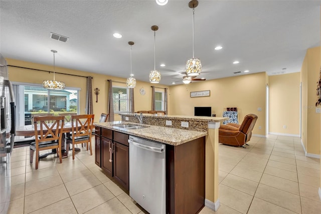 15506 Gemini Dr, Mascotte, FL 34753 - kitchen with sink, hanging light fixtures, stainless steel dishwasher, light tile patterned floors, and a center island with sink