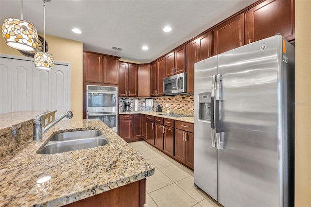 15506 Gemini Dr, Mascotte, FL 34753 - kitchen with sink, hanging light fixtures, backsplash, stainless steel appliances, and light tile patterned flooring