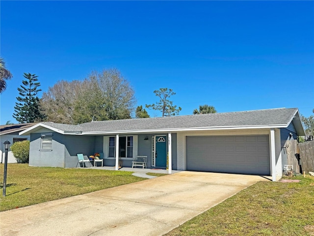 ranch-style home featuring brick siding, a front yard, an attached garage, and driveway