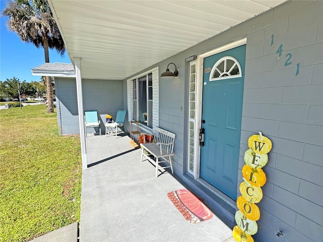 view of exterior entry featuring a lawn