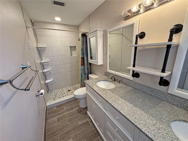 full bath featuring wood finish floors, visible vents, toilet, a stall shower, and vanity