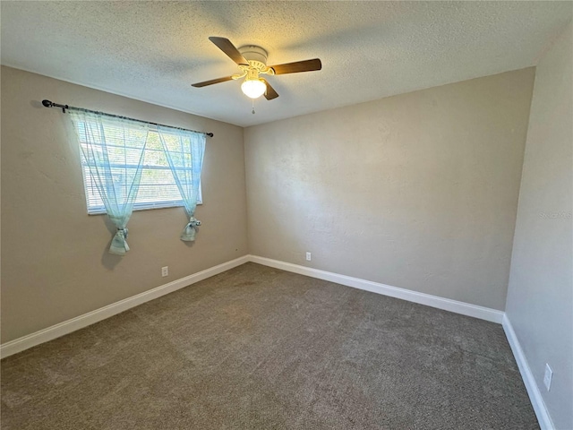 spare room with ceiling fan, baseboards, dark colored carpet, and a textured ceiling