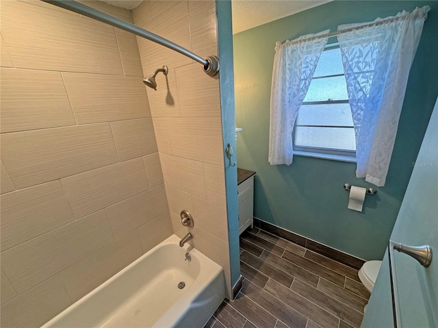 full bathroom featuring vanity, baseboards, wood tiled floor, toilet, and shower / bathtub combination