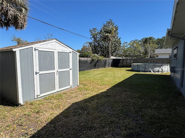 view of yard with an outbuilding, a shed, a fenced in pool, and a fenced backyard