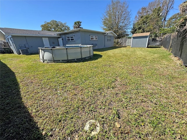 view of yard with an outdoor pool, a storage unit, an outbuilding, and a fenced backyard