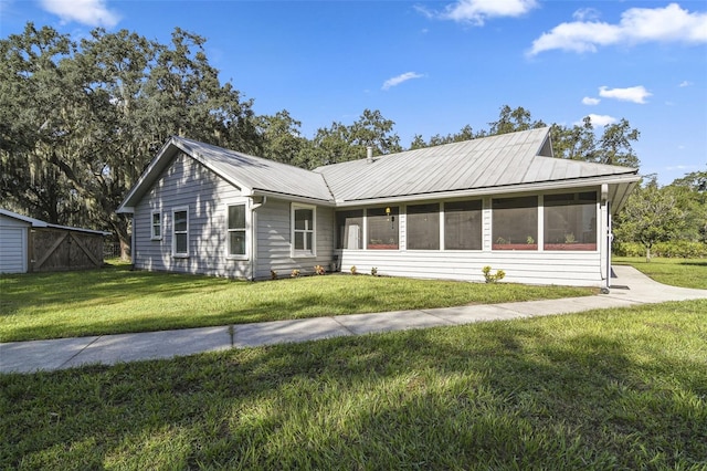 ranch-style house featuring metal roof and a front lawn