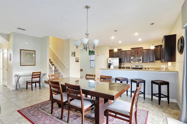 dining area with a notable chandelier and light tile patterned floors