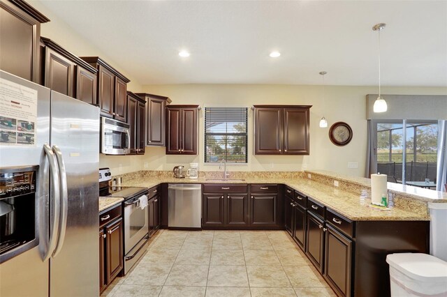 kitchen with appliances with stainless steel finishes, kitchen peninsula, sink, and hanging light fixtures