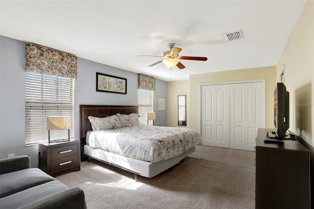 bedroom featuring light carpet, a closet, and ceiling fan