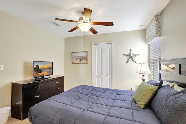 bedroom featuring ceiling fan, light carpet, and a closet